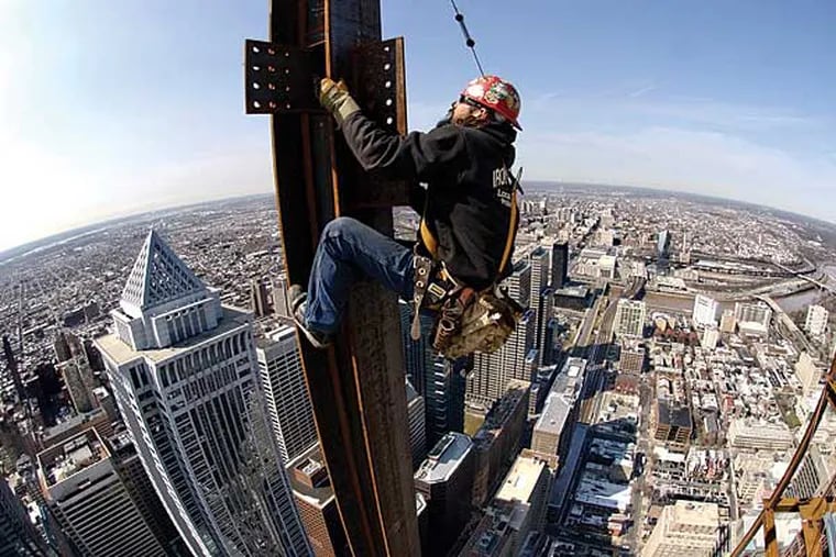 FILE photo of a worker at a construction site with Philadelphia skyline in the backdrop. The metro area was ranked fourth nationally for the pace at which job openings grew in April. (BARBARA L. JOHNSTON / Staff / File)