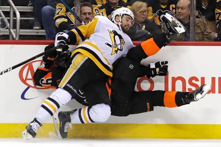 The Flyers' Ivan Provorov (9) colliding with the Penguins' Zach Aston-Reese during the second period Saturday.
