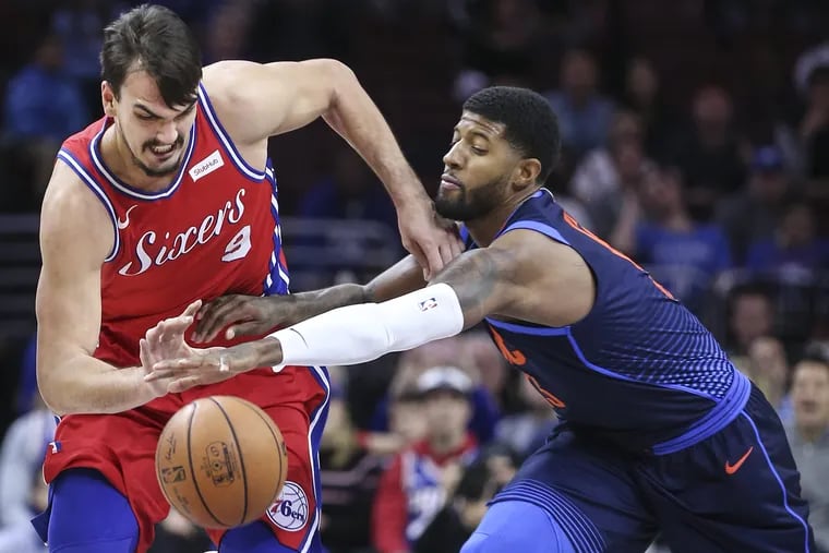 Paul George knocks the ball away from the Sixers' Dario Saric during a December 2017 game. The Sixers are reportedly targeting George, who will become a free agent.
