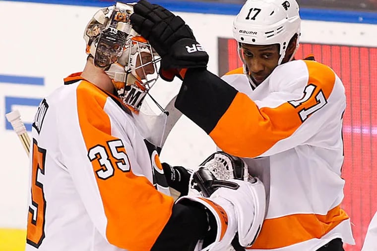 Steve Mason (35) and right wing Wayne Simmonds (17) celebrate after defeating the Florida Panthers 3-2 in an NHL hockey game in Sunrise, Fla., on Tuesday, April 8, 2014. (Terry Renna/AP)