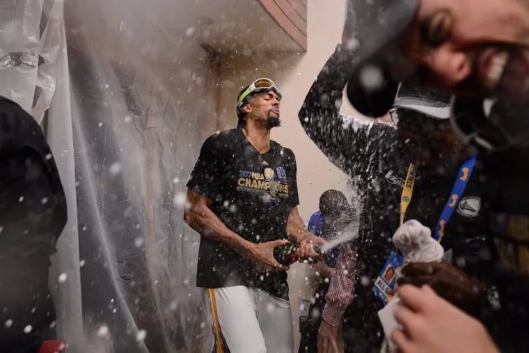 The Golden State Warriors' James Michael McAdoo celebrates in the locker room after the team won the NBA championship over the Cavaliers.