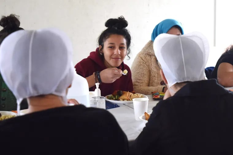 Syrian refugee Hevin Khilo, center, is shown having a conversation and lunch with an Amish family Saturday Dec. 14, 2019 in Strasburg, Pa.