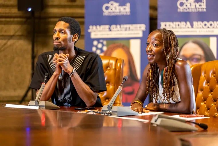 Reparations Task Force Co-Chair’ Breanna Moore, (right), and Rashaun Williams, (left), open up the mic for community members who signed up to speak at the meeting at City Hall in Philadelphia, Pa., on Tuesday, May, 21, 2024.