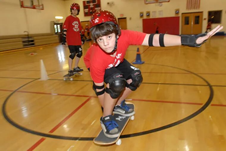 Andre Domingue, 13, takes part in Kingsway Regional High School's skateboarding lesson as taught by Bill Ewe. ( April Saul / Staff Photographer )