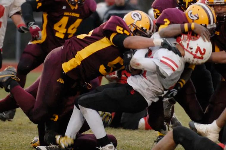 Glassboro linebackers Gary Scruggs and Timothy Breaker crush Penns Grove&#0039;s Darrion Mills during the South Jersey Group 1 championship. The 12-0 Bulldogs had nine players finish with 40 or more tackles - senior linebacker Josh Bell made 79.