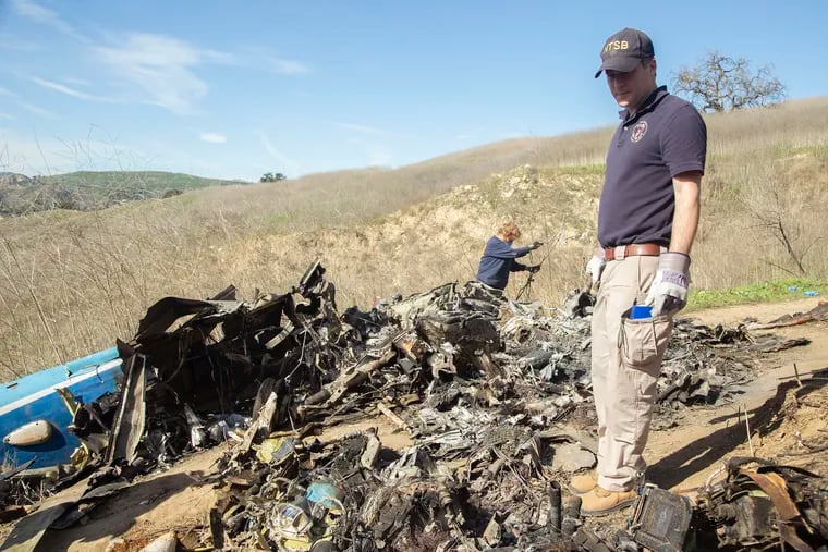 NTSB investigators Adam Huray, right, and Carol Hogan examine wreckage as part of the NTSB's investigation of a helicopter crash near Calabasas, Calif., on Jan. 27.