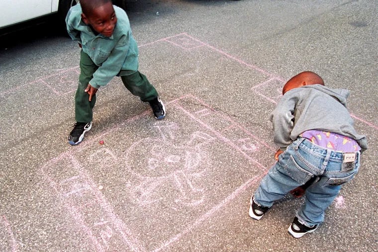During the Rowhouse Olympics in Old City in 1997, brothers Khalil Cheely, 7, (left) and Joshua, 6, of West Philadelphia play a game of deadbox.