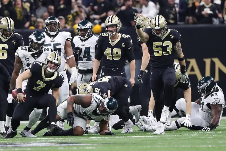 Taysom Hill (left) gets the first down as Fletcher Cox (far right) goes down injured on the play.