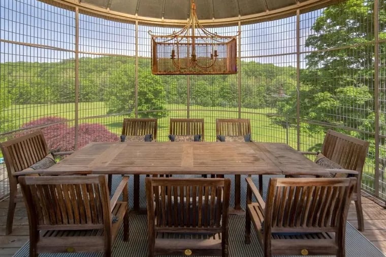 A unique outdoor dining in an oversized aviary at 61 Sheep Hole Road in Ottsville looks out at the in-ground pool.