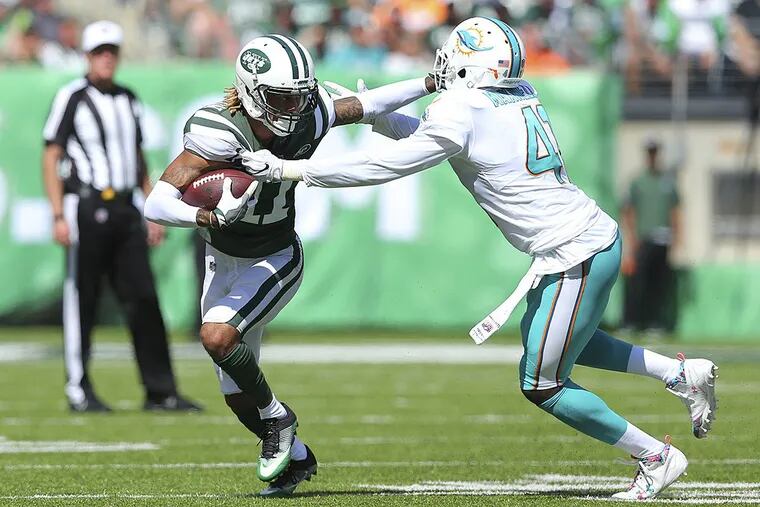 Byron Maxwell (41) gets stiff-armed by Jets wide receiver Robby Anderson (11) earlier this season.