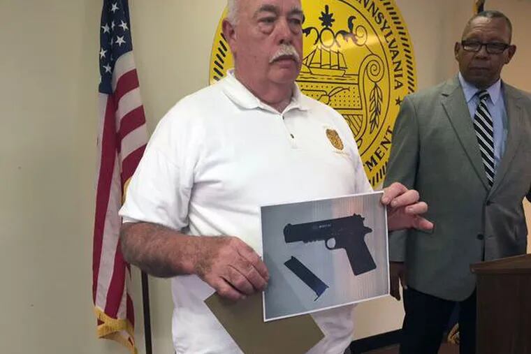 Chester Police Commissioner Joseph M. Bail Jr. displays an image of the gun as Chester Mayor
John Linder looks on. Bail called for new rules on detaining juveniles suspected of crimes. (CAITLIN McCABE/Inquirer Staff)