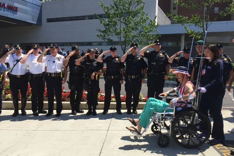 Police salute Folcroft officer Chris Dorman as he is released from the hospital on Monday, June 27, 2016.
