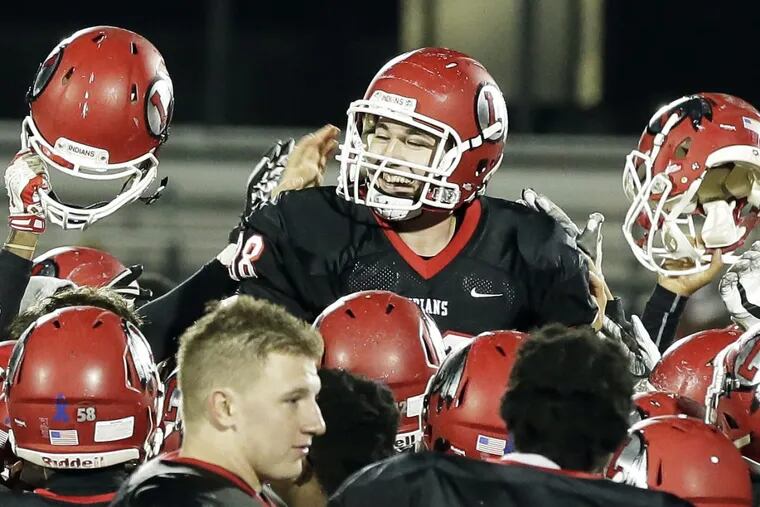 Lenape players lift up kicker Stephen Mulville after he booted the winning field goal Saturday night against Rancocas Valley.