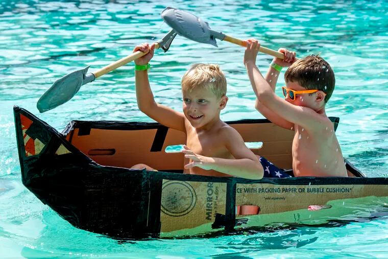 Asher Creato, 6, (left) and his brother Alec, 8, paddle their boat during the Eighth Annual Cardboard Boat Regatta at the Ridley Park Swim Club on Labor Day.