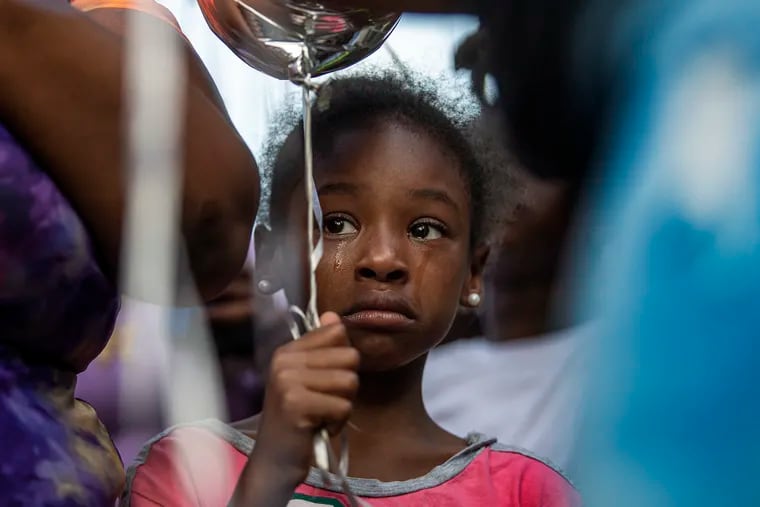 A little girl share tears in memory of Alexis Quinn, who was killed in the South Street shooting, during a vigil and balloon release in Philadelphia on Wednesday, June 8, 2022.