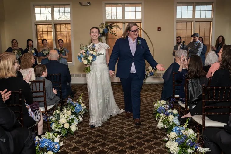 Kathryn Hilton (left) and Stephanie Hilton celebrate as they walk down the aisle after their wedding ceremony.