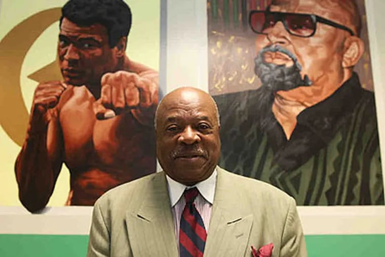 Founder Walter D. Palmer, at Palmer Leadership Learning Charter in North Phila., is flanked by portraits of social activists Muhammed Ali (left) and Kwanzaa pioneer Maulana Karenga. (Juliette Lynch / Staff Photographer)