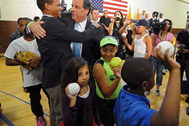Gov. Chris Christie embraces Bryan Morton, founder of North Camden Little League, after Christie addresses supporters at the Roberto Clemente Community Center in Camden during a campaign event July 16, 2015. ( CLEM MURRAY / Staff Photographer )