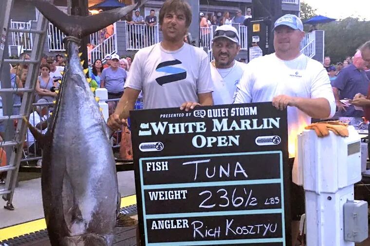 Rich Kosztyu (left), Damien Romeo, and Brian Suschke (right) celebrate their catch at weigh-ins at the White Marlin Open.