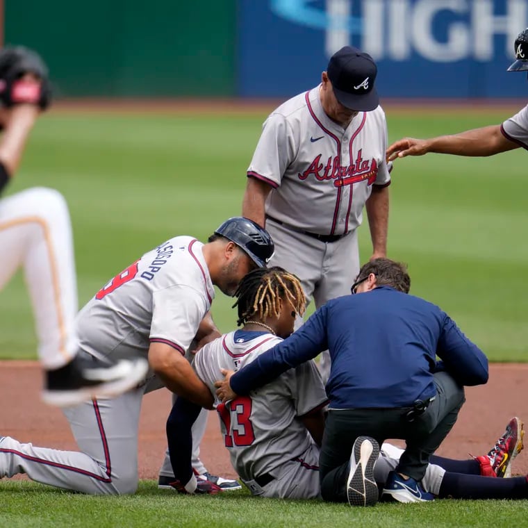 Atlanta Braves outfielder Ronald Acuña Jr. is tended to after he hurt his left knee running the bases against the Pittsburgh Pirates on Sunday.