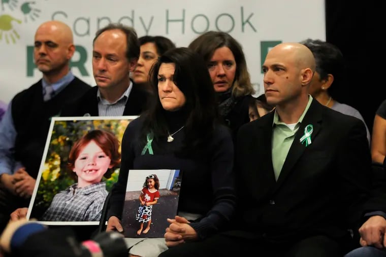 Jeremy Richman, right, during a press conference on Jan. 14, 2013 beside his wife Jennifer Hensel, center, holding a photo of their daughter Avielle, who was killed in the Dec. 14, 2012 Sandy Hook Elementary School shooting. Jeremy Richman was found dead early Monday, March 25, 2019 at Edmond Town Hall in Newtown, Conn., police said.