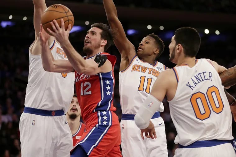 Sixers’ point guard T.J. McConnell, second from left, drives to the basket through New York Knicks defenders during the second half of the NBA basketball game, Monday, Dec. 25, 2017, in New York. The 76ers defeated the Knicks 105-98.