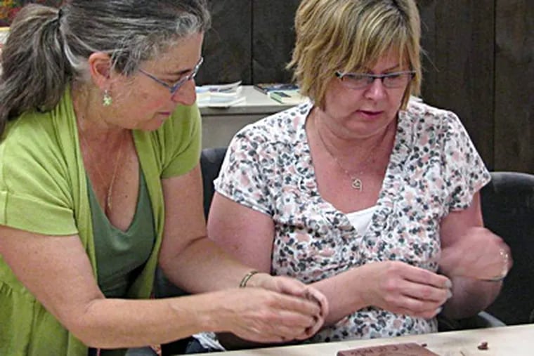 Tile artist Karen Singer (left) leads a workshop for caregivers like Tracey Smay of Elizabethtown during a retreat hosted by Nancy&rsquo;s House.   ELISSA LEWIN