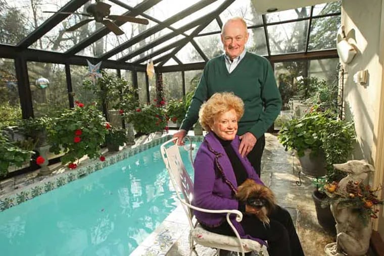 Howard and D-J Brosius and their Pekingese, Misu, in their greenhouse/pool/great room.