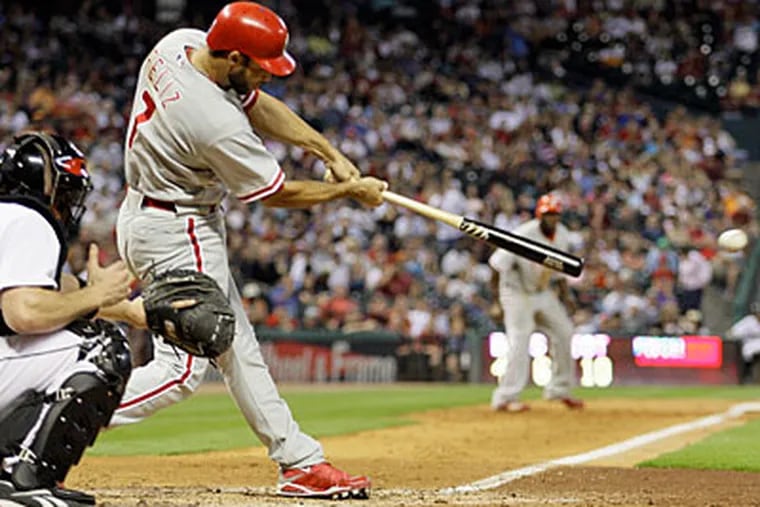Pedro Feliz (7) hits an RBI-single to score teammate Ryan Howard from third base as Houston Astros catcher Chris Coste, left, reaches for the pitch during the eighth inning of a baseball game Saturday, Sept. 5, 2009 in Houston. (AP Photo/David J. Phillip)