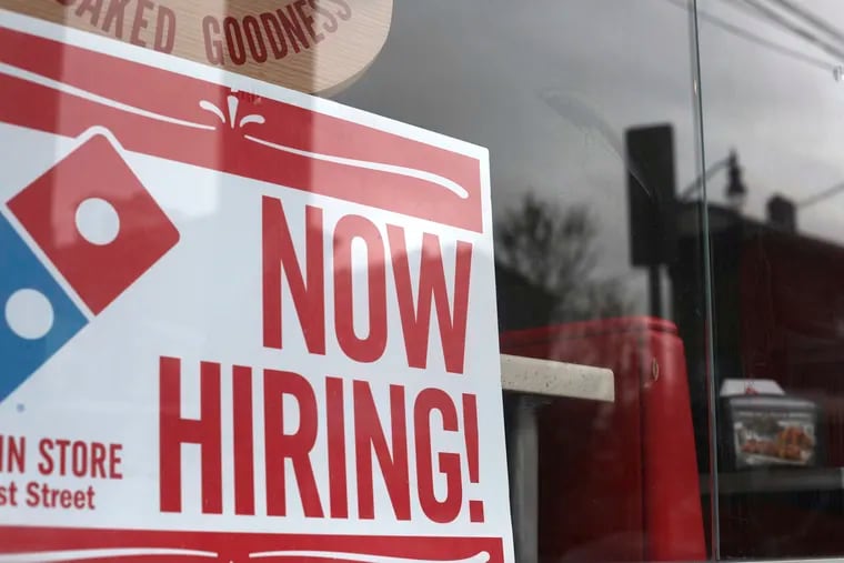 File photo shows a 'now hiring' sign  posted at a Domino's Pizza in Jersey City, N.J. Companies that serve consumers face-to-face or deliver food and essentials to homes are eager to hire, including well known names such as Walmart, Amazon, Domino’s, Papa John's, and CVS.