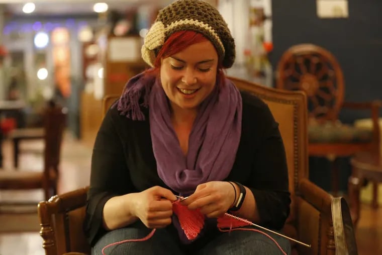 Brianna Borouchoff knits a hat with cat-shaped ears on top aka a 'Pussy Hat,' during a meet-up at Higher Grounds Cafe in Philadelphia on January 16, 2017. The hat-making / wearing project was in response to Donald Trump's infamous remark about grabbing women by their . . . you know what.