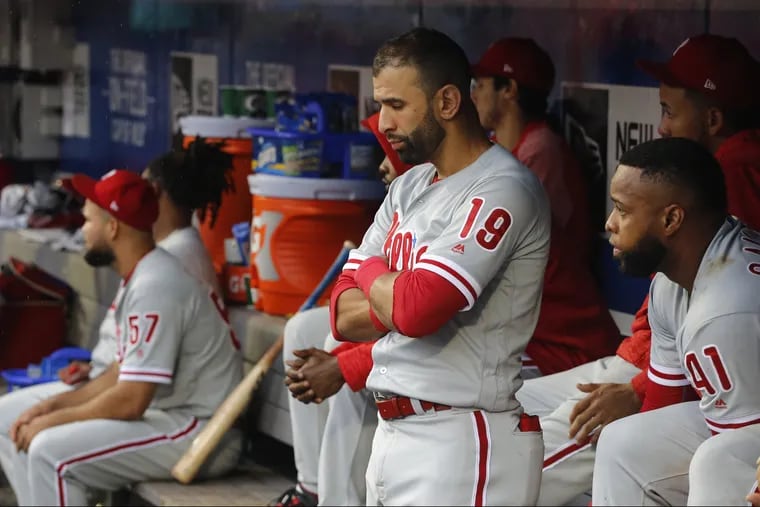 Phillies Jose Bautista, center, and Carlos Santana, right, in the dugout during the ninth inning Sunday against the Mets,