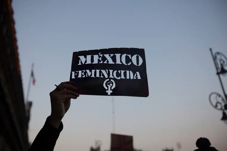 A demonstrator holds up a stencil of the Spanish message: "Mexico Femicide" in Mexico City on Friday. The demonstration against gender violence comes after last week's vicious murder of Ingrid Escamilla by her husband and controversy unleashed by the leaking of images of her body to the press, in a country where an average of 10 women are killed every day.