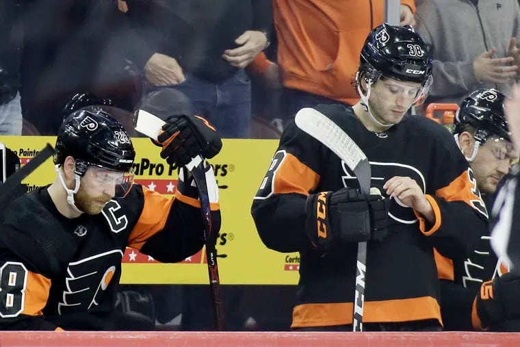 Flyers forwards Claude Giroux (left) and Ryan Hartman have dejected looks as their team faced a 2-0 second-period deficit Sunday. The New York Rangers won, 3-0.