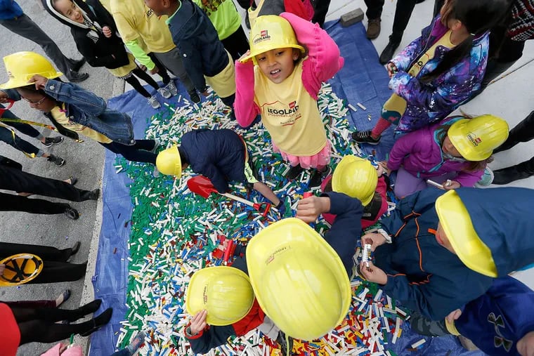 Children from Plymouth Elementary School play in a pile of more than 50,000 Lego pieces that were dumped at the future site of Legoland Discover Center during a news conference at the Plymouth Meeting Mall on Oct. 25, 2016.