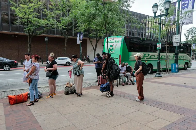File photo of people waiting at the curbside bus station along the 600 block of Market Street in July.