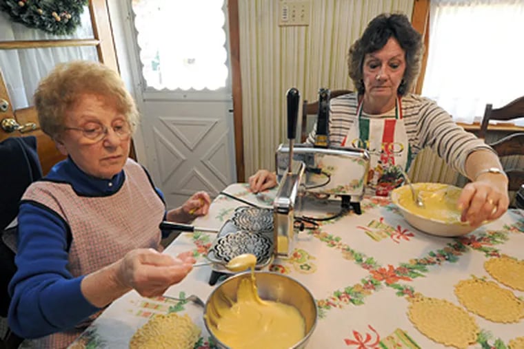 Dolly Braccischi (left) and Mary Ann Bruno make pizzelles at the Plymouth Meeting home of Bruno's mother-in-law, Josephine Bruno. They expected to make 500. (April Saul / Staff Photographer)