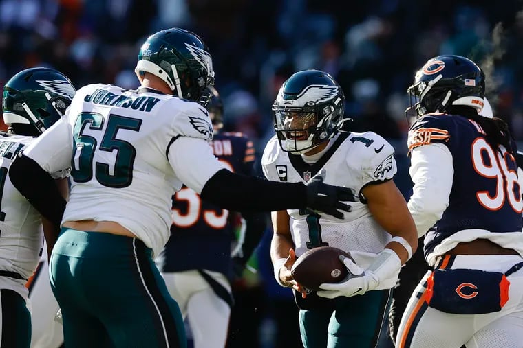 Eagles quarterback Jalen Hurts celebrates his third quarter 1-yard touchdown run with teammate offensive tackle Lane Johnson against the Chicago Bears on Sunday, December 18, 2022 in Chicago.