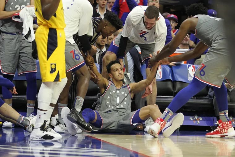 Landry Shamet, center, of the Sixers is helped to his feet after hitting a 3-pointer and getting fouled against the Pacers during the 1st half at the Wells Fargo Center on Dec. 14, 2018.    CHARLES FOX / Staff Photographer