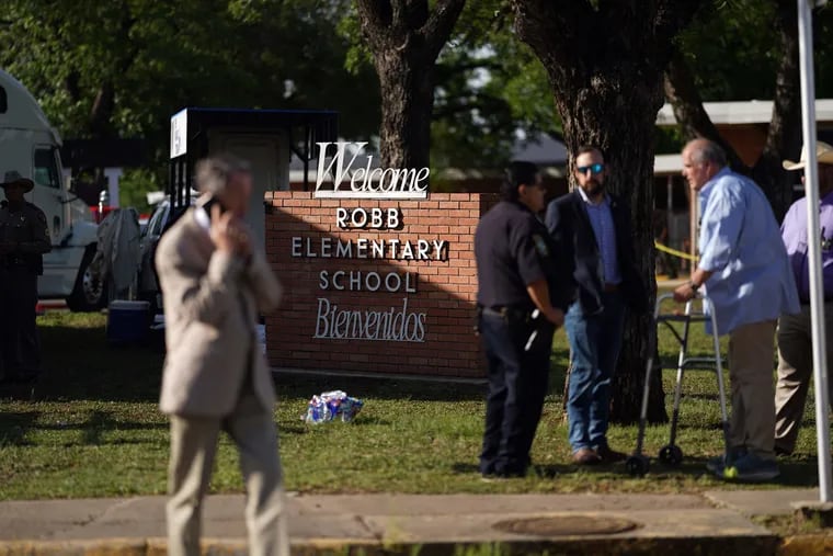 Uvalde, Texas, Mayor Don McLaughlin (R) speaks with an officer outside Robb Elementary School in Uvalde, Texas, on May 25, 2022. Caregivers struggling with how to talk to children about the mass shooting can start by listening to what their kids say.