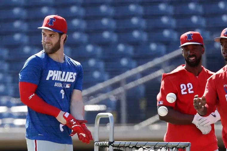 Bryce Harper with new Phillies teammates Andrew McCutchen and Jean Segura after they finished batting practice during spring training.