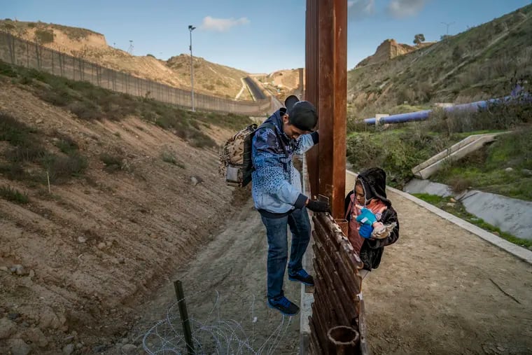 A migrant girl holds her doll as she climbs the U.S. border fence before jumping into the U.S. side to San Diego, Calif., from Tijuana, Mexico, Thursday, Dec. 27, 2018. Discouraged by the long wait to apply for asylum through official ports of entry, many Central American migrants from recent caravans are choosing to cross the U.S. border wall and hand themselves into border patrol agents.