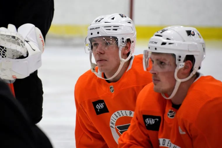 Ronnie Attard, left, and Nick Seeler listen to instructions at Flyers practice on Thursday, Mar. 31, 2022. It was Attard's first practice.