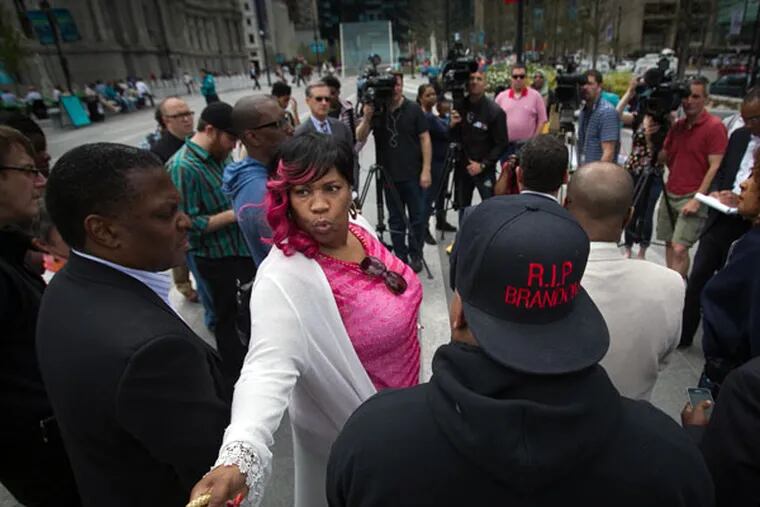 Tanya Brown-Dickerson, mother of Brandon Tate-Brown, turns to hand her purse during a news conference Wednesday, April 29, at Dilworth Park. (ALEJANDRO A. ALVAREZ/Staff Photographer)