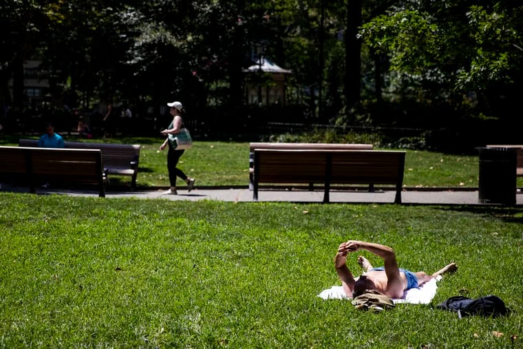 A person sun tanning at Rittenhouse Square on a hot afternoon in Philadelphia on Saturday, July 23, 2022.