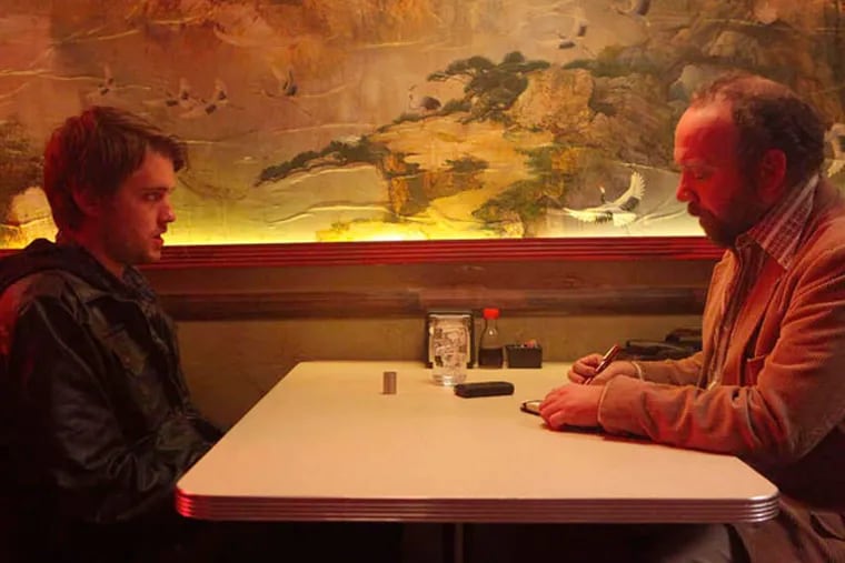 Chase Williamson (left) as Dave Wong is interviewed by a journalist played by Paul Giamatti in &quot;John Dies at the End.&quot;