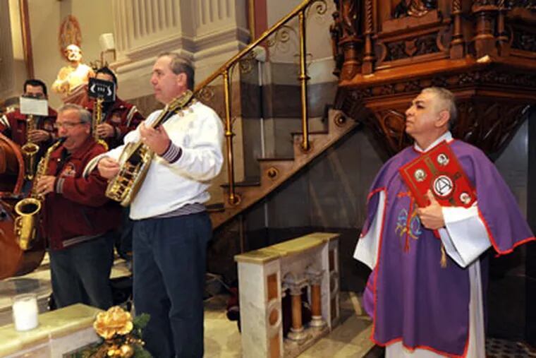 PMUMMERS19P8  In Philadelphia, the 29th annual Mummers Mass at St. Peters Church at 5th and Girard, plus the Polish-American String Band practicing at Front and Mifflin.  Here, at the church, members of the Quaker City String Band play; at right is Deacon Juan Ramos  12/18/11  APRIL SAUL / Staff Photographer