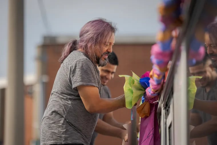 César Viveros, the lead visual artist for the short film La Guagua 47, adds flowers to a SEPTA bus for the film. Viveros and other community leaders created Street Knowledge, a program offering free and low-cost classes taught by community members, for community members.