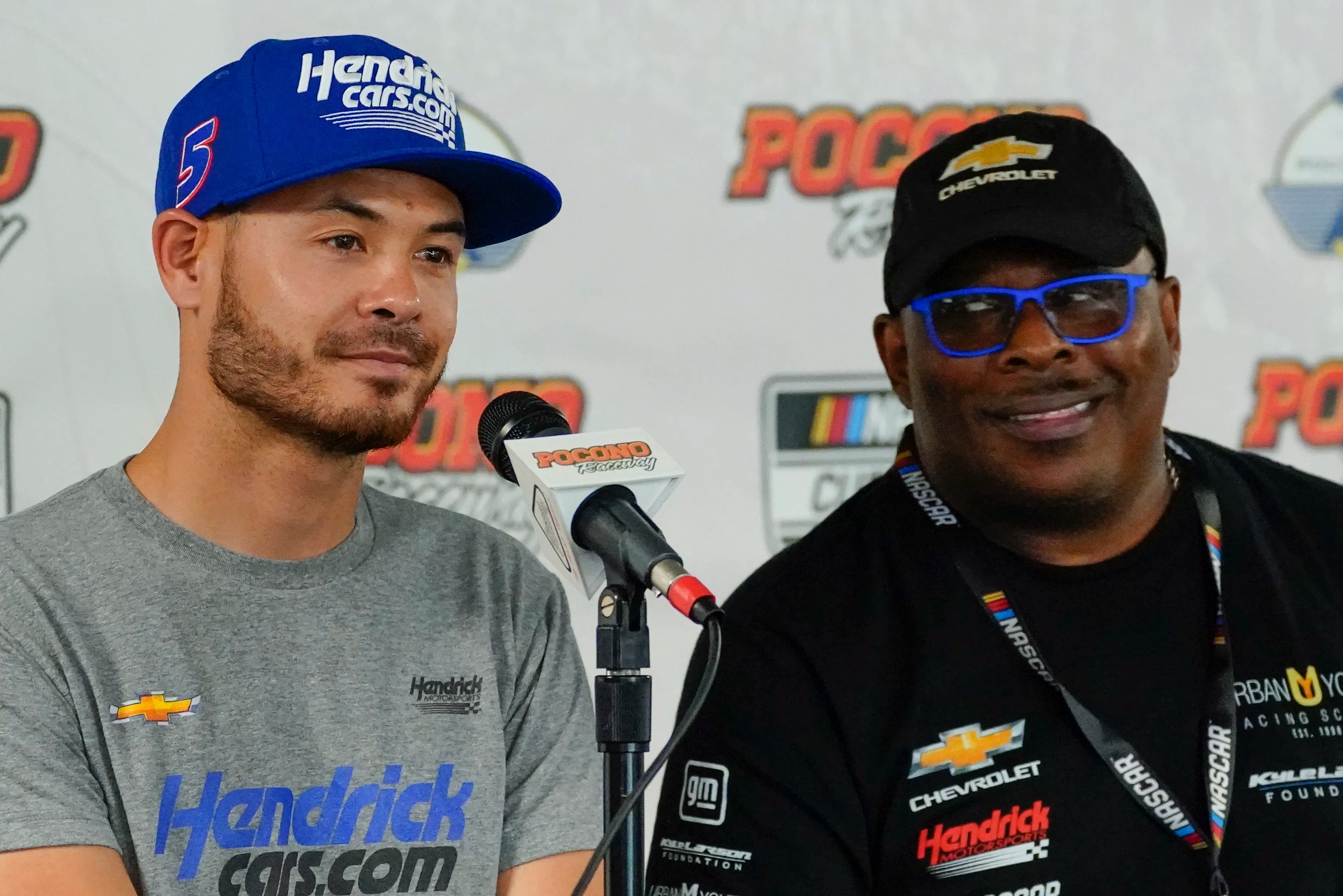 Anthony Martin, right, who established the Urban Youth Racing School, speaks at a news conference as he sits with Kyle Larson  before races at Pocono Raceway on June 27, 2021. 