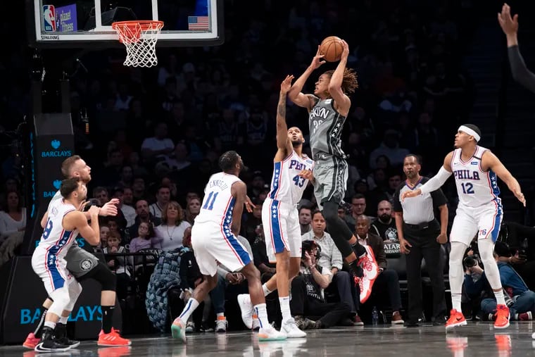 Brooklyn Nets forward Nicolas Claxton goes to the basket past  76ers forwards James Ennis III (11),  Jonah Bolden (43) and Tobias Harris (12) during the first half.